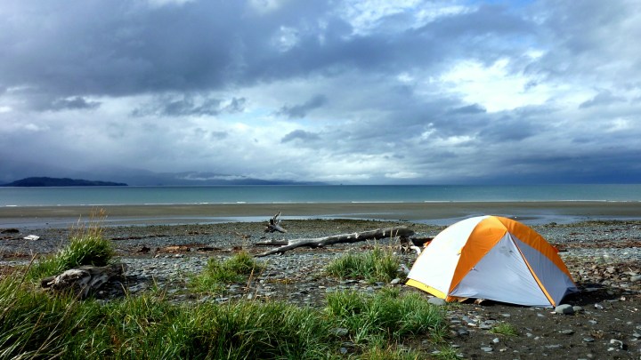 White and orange tent on a beach in Alaska