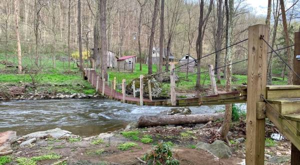 Walk Across A Suspension Bridge To Reach This Whimsical Maryland Cabin On The Creek