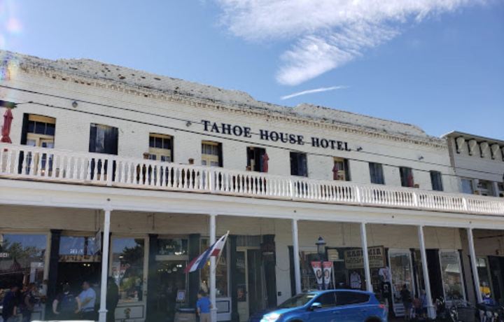 Exterior view of the Tahoe House Hotel in downtown Virginia City, NV which showcases a white wraparound upper level porch