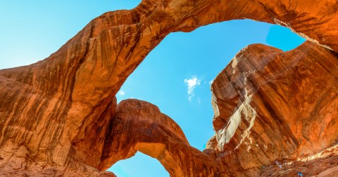 Double Arch is one of the most impressive natural rock formations in Arches National park. People climb on the rocks, take photos, and explore this landmark.