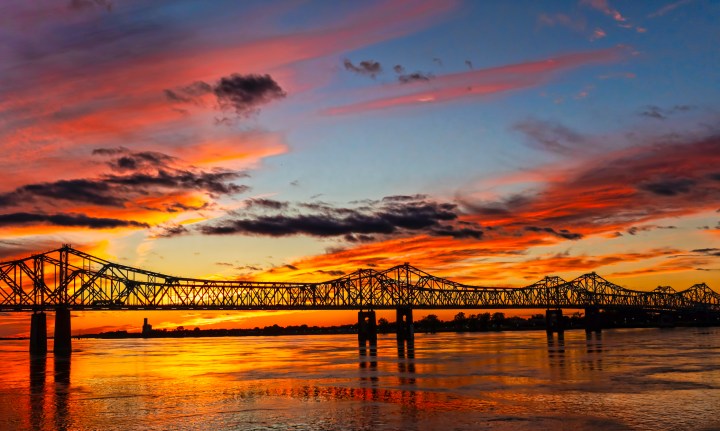 As the sun sets it silhouettes the Natchez–Vidalia Bridge which are two twin cantilever bridges carrying U.S. Route 84, and 425 between Vidalia, Louisiana and Natchez, It is the tallest bridge in Mississippi.