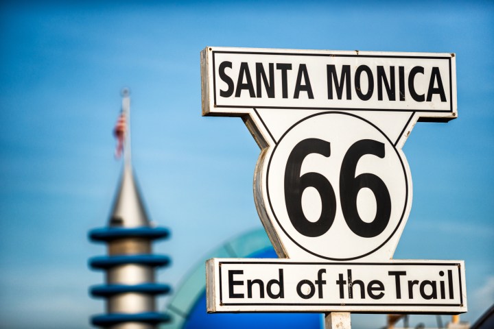 Santa Monica end of the trail sign with USA flag in the background.