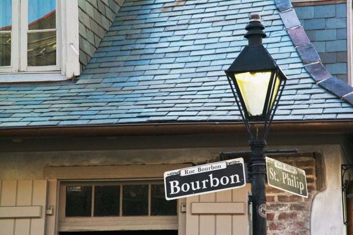 Bourbon Street sign with the haunted Lafitte's Blacksmith Shop in the background, New Orleans, Louisiana