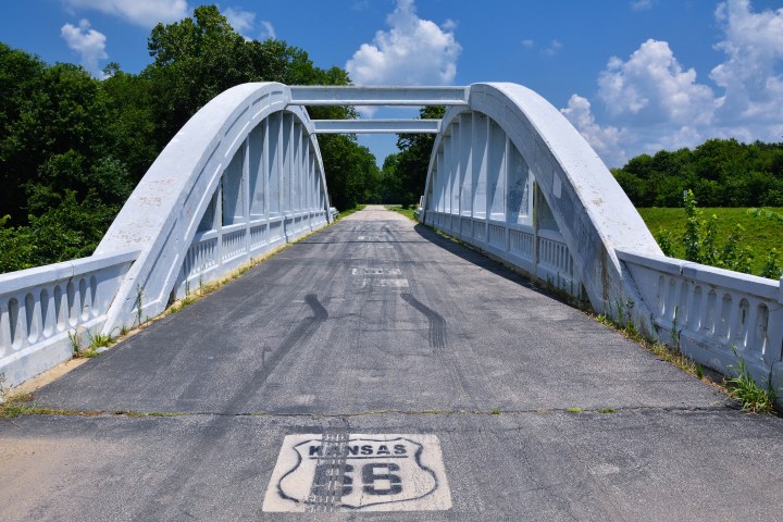 Close up of this Rainbow Curve Bridge Constructed in 1923 that is the only remaining Marsh Arch Bridge on Route 66. Route 66 signs are painted on the pavement.