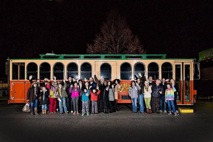 Tour group outside trolley at night