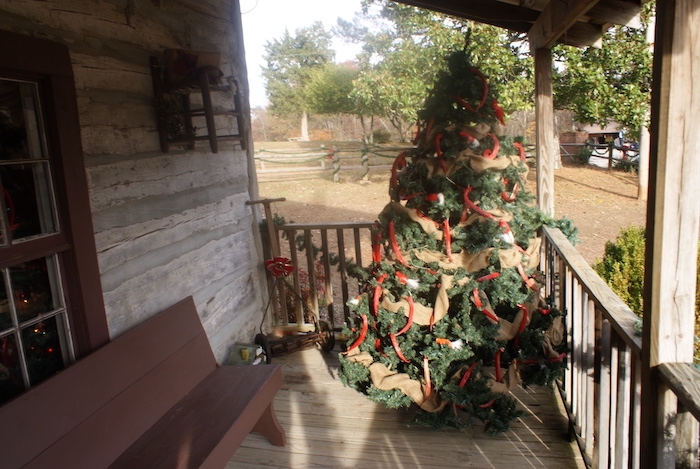 A decorated tree on a cabin porch at LaGrange Historic Site's Christmas in the Country event allows guests to experience a pioneer Christmas in Alabama.