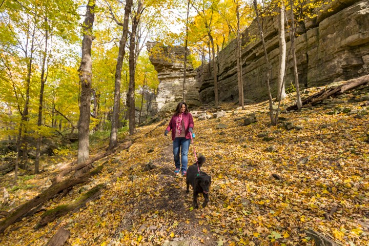 A woman and her dog enjoy a hike on a nice fall day at High Cliff State Park in Sherwood, Wisconsin